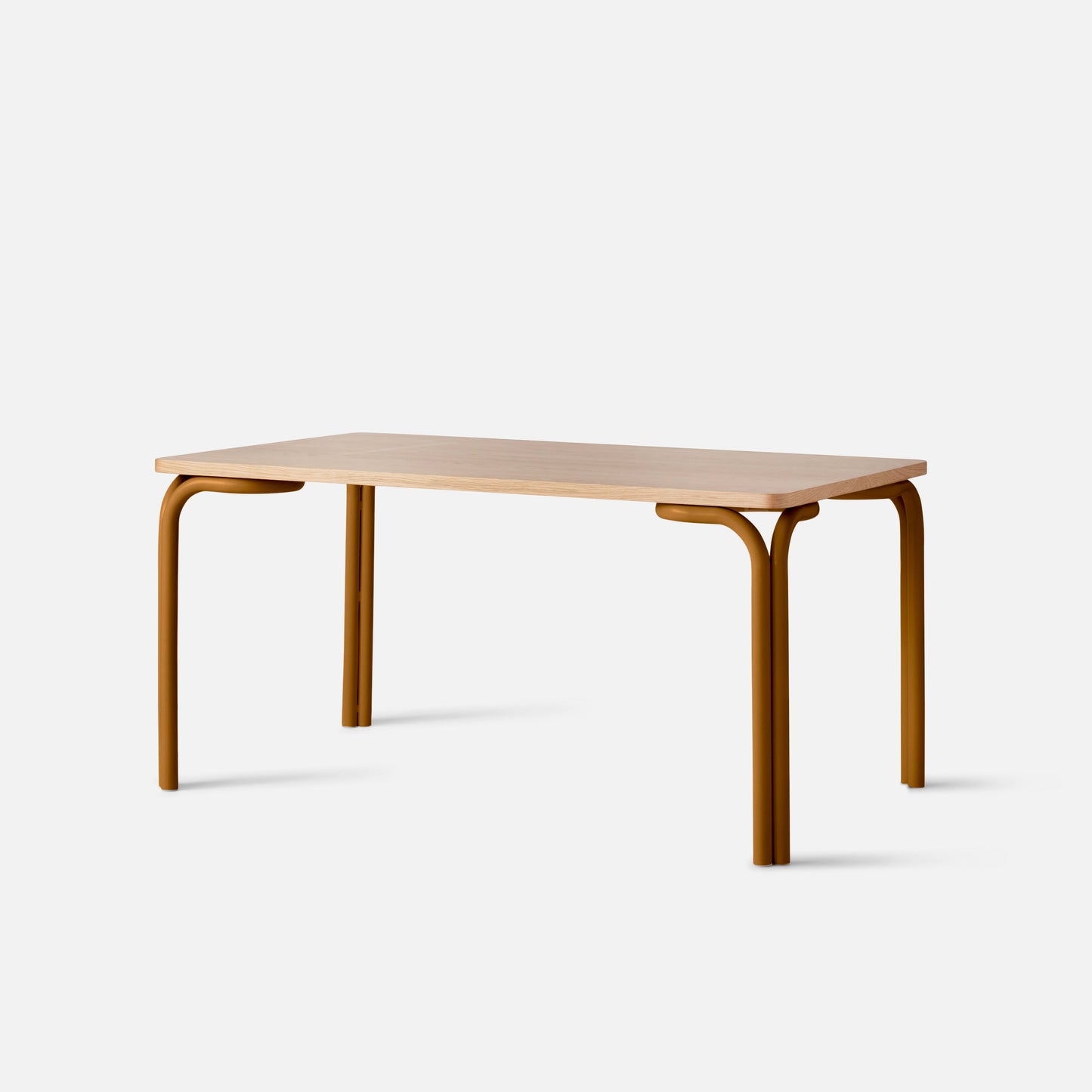 Angled view of Forma Dining Table showcasing a light-wood rectangular top with rounded edges and butterscotch-satin tubular legs with a white background