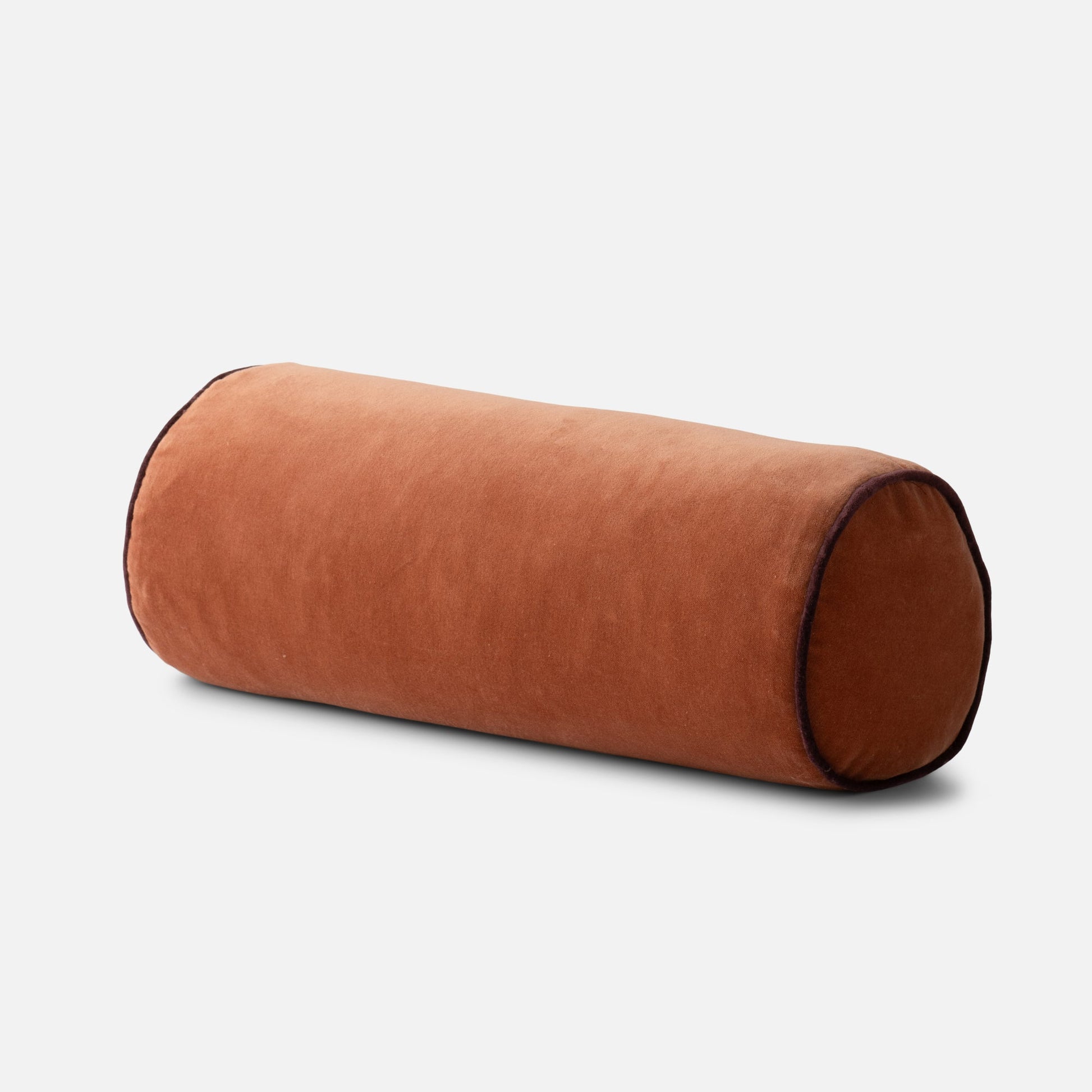 Angled front view of Velvet Piped Pillow (bolster) showcasing tawny cotton velvet and contrast piping on white background
