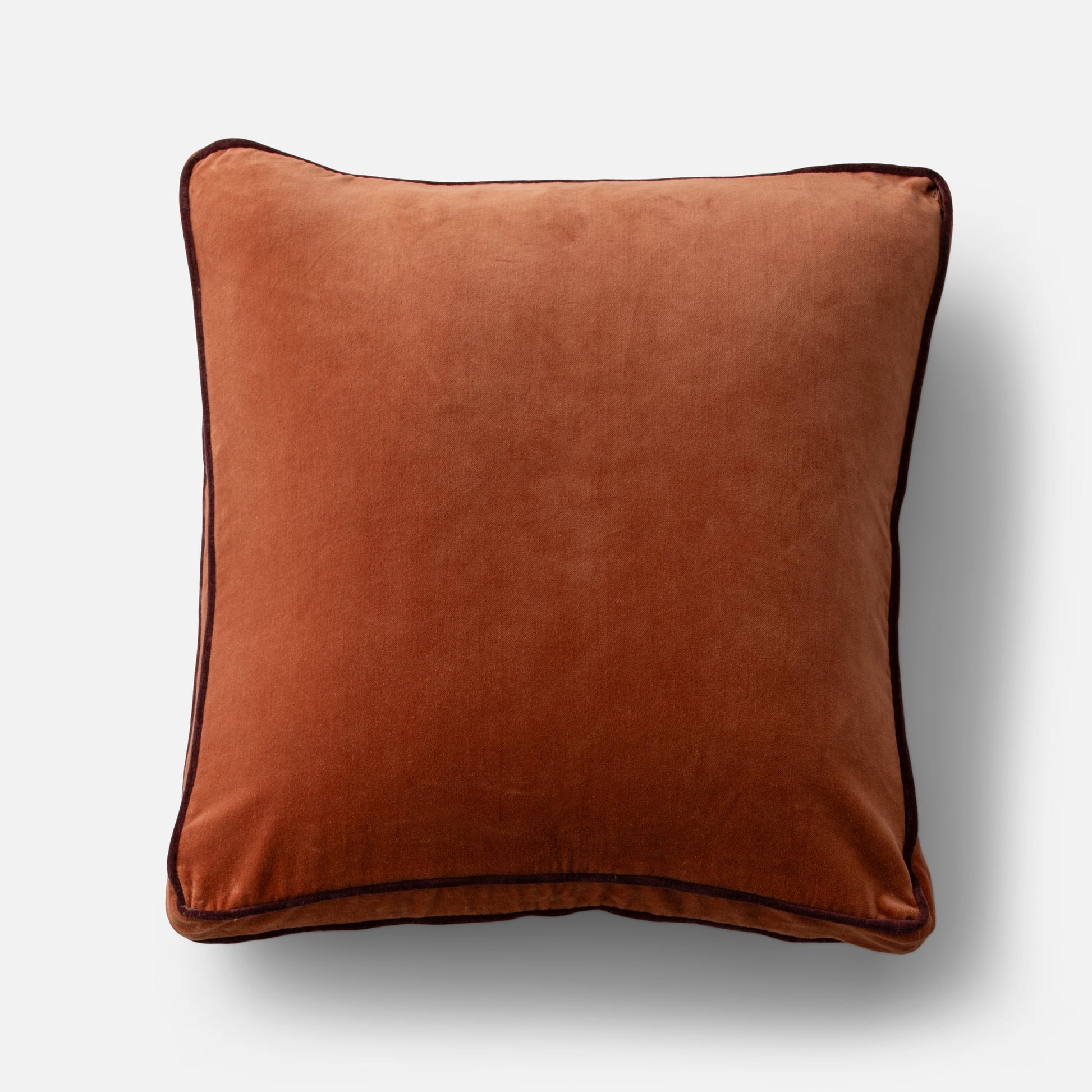 Overhead view of Velvet Piped Pillow showcasing tawny 100 percent cotton velvet and dark contrast piping on light gray