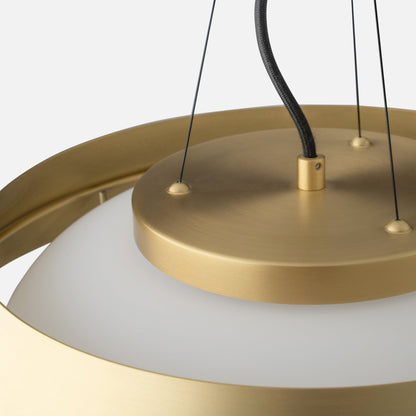 Close-up of Alfred Pendant showing natural brass finish, braided black cord, and white opal glass on light gray