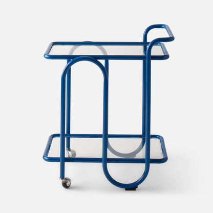 Front view of Lolly Bar Cart showcasing cobalt gloss bent steel frame, two tempered glass shelves and caster wheels on white background
