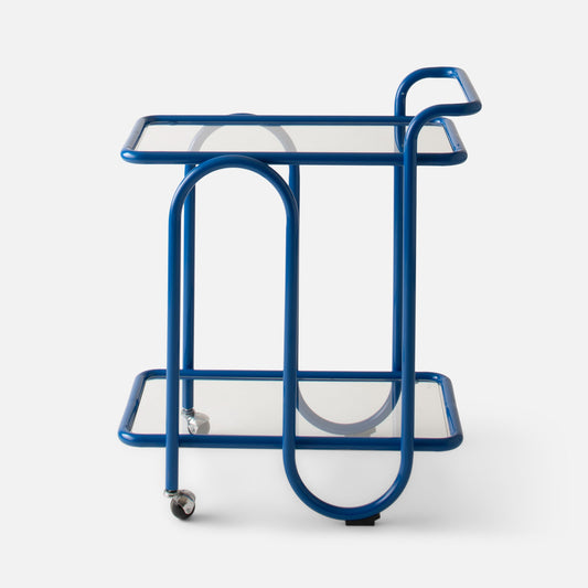 Front view of Lolly Bar Cart showcasing cobalt gloss bent steel frame, two tempered glass shelves and caster wheels on white background