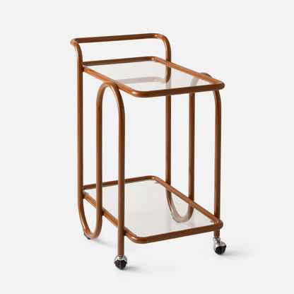 Quarter view of Lolly Bar Cart showcasing bent steel frame, tempered glass shelf, and caster wheel on white background