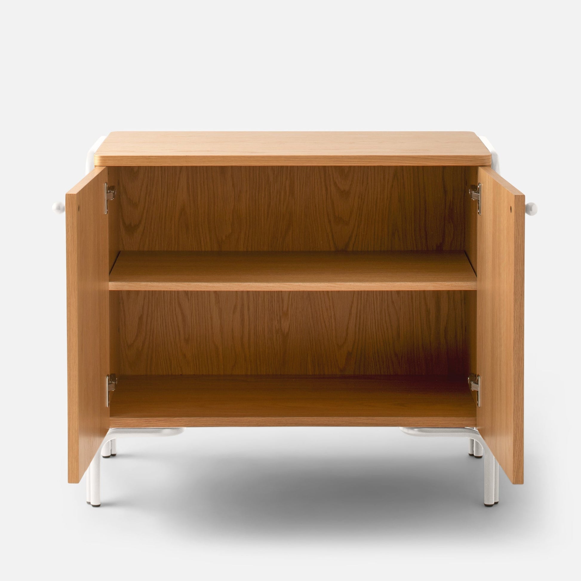 Front view of Forma Cabinet with open doors showing oak veneered interior shelves and white powder-coated steel legs on a white background
