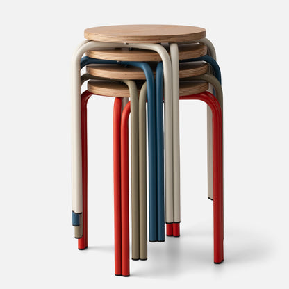 Close-up front view of stacked Forma Stool showcasing oak plywood tops and powder coated steel legs in red, indigo, shell white, and lichen on a light background