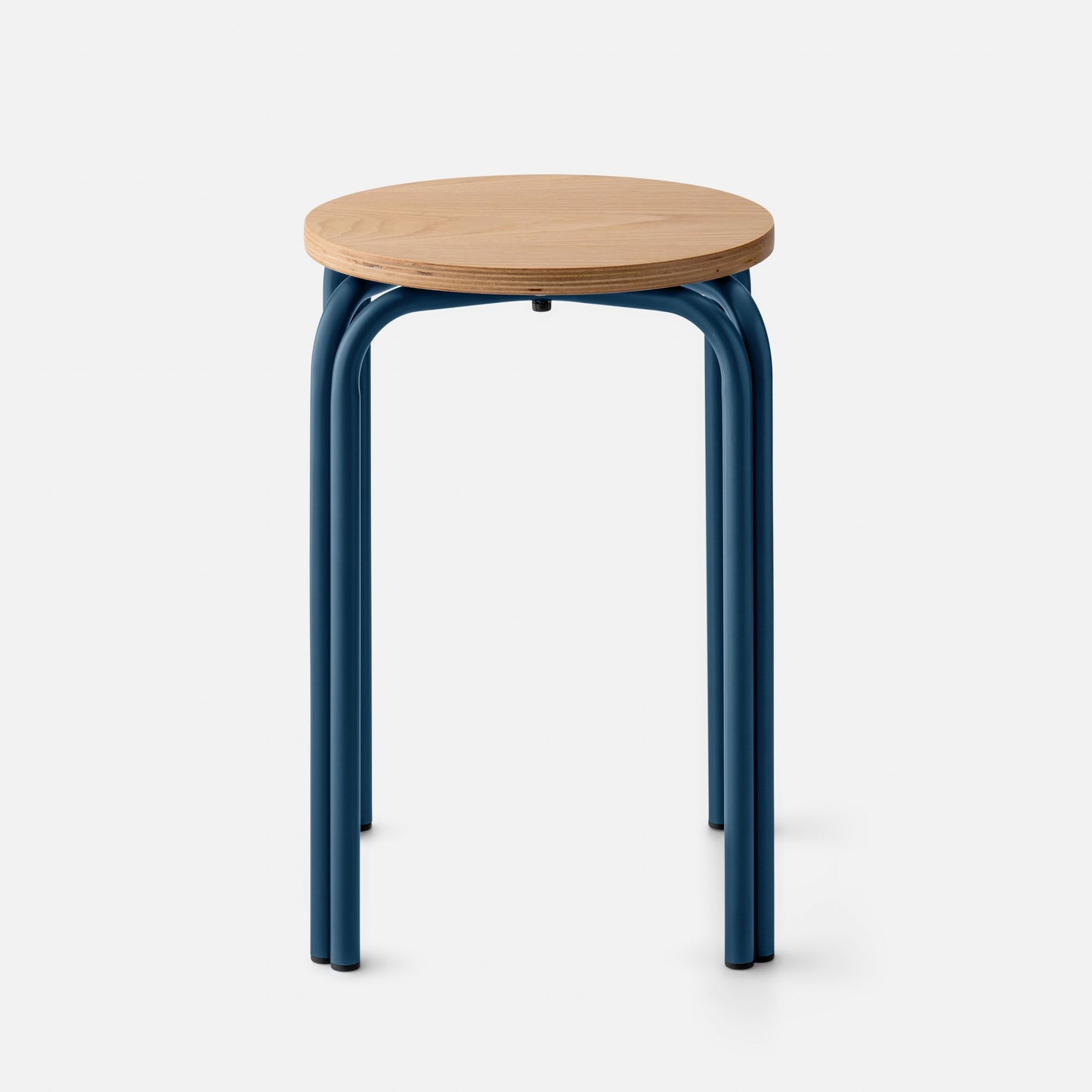 Front close-up of Forma Stool showing oak top and exposed plywood edge with indigo satin curved steel legs on white