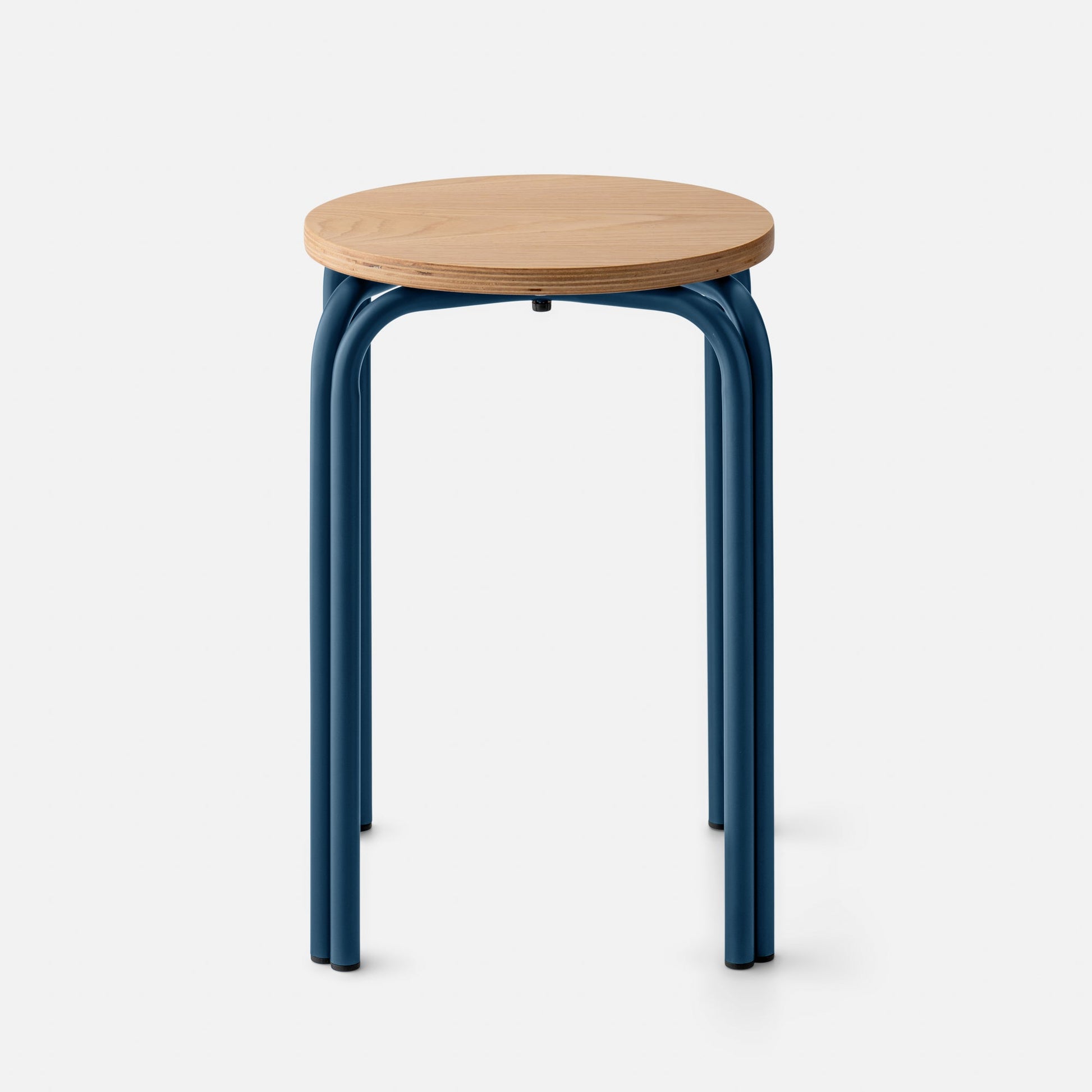 Front close-up of Forma Stool showing oak top and exposed plywood edge with indigo satin curved steel legs on white