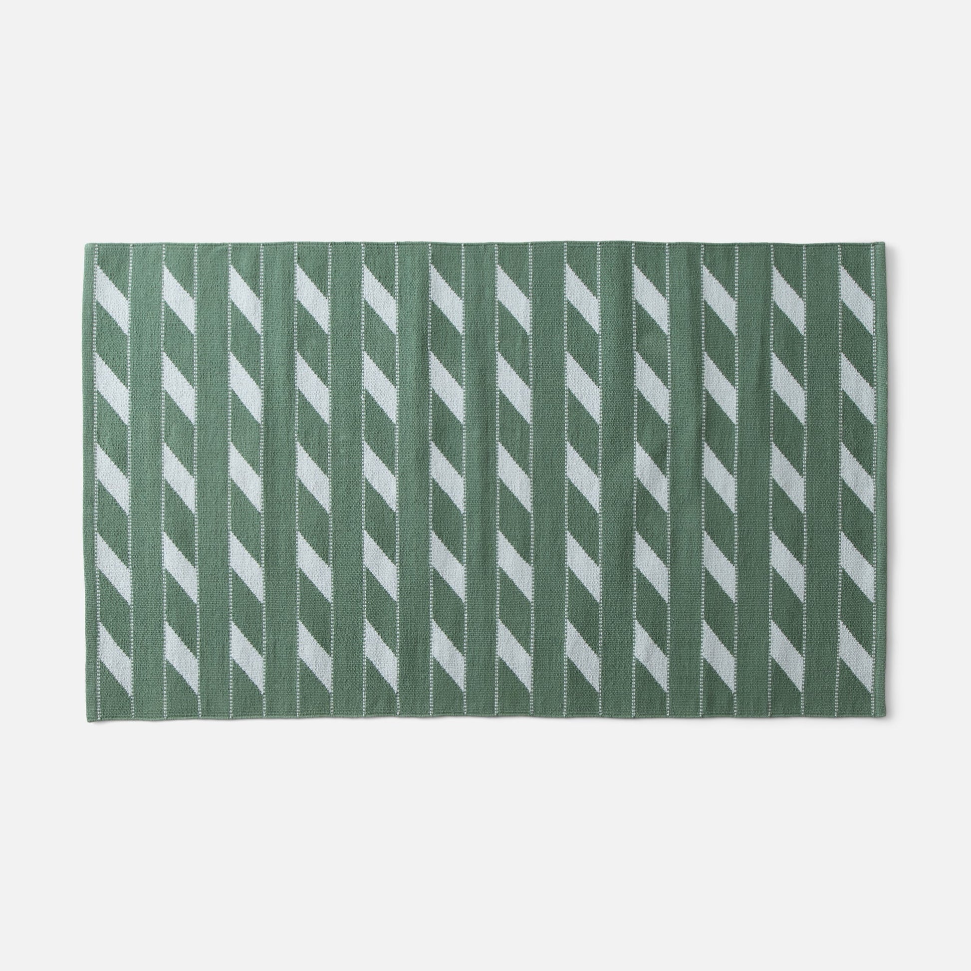 Flat-lay of Cotton Ladder flatweave rug showcasing green ladder stripe pattern and woven texture on white background