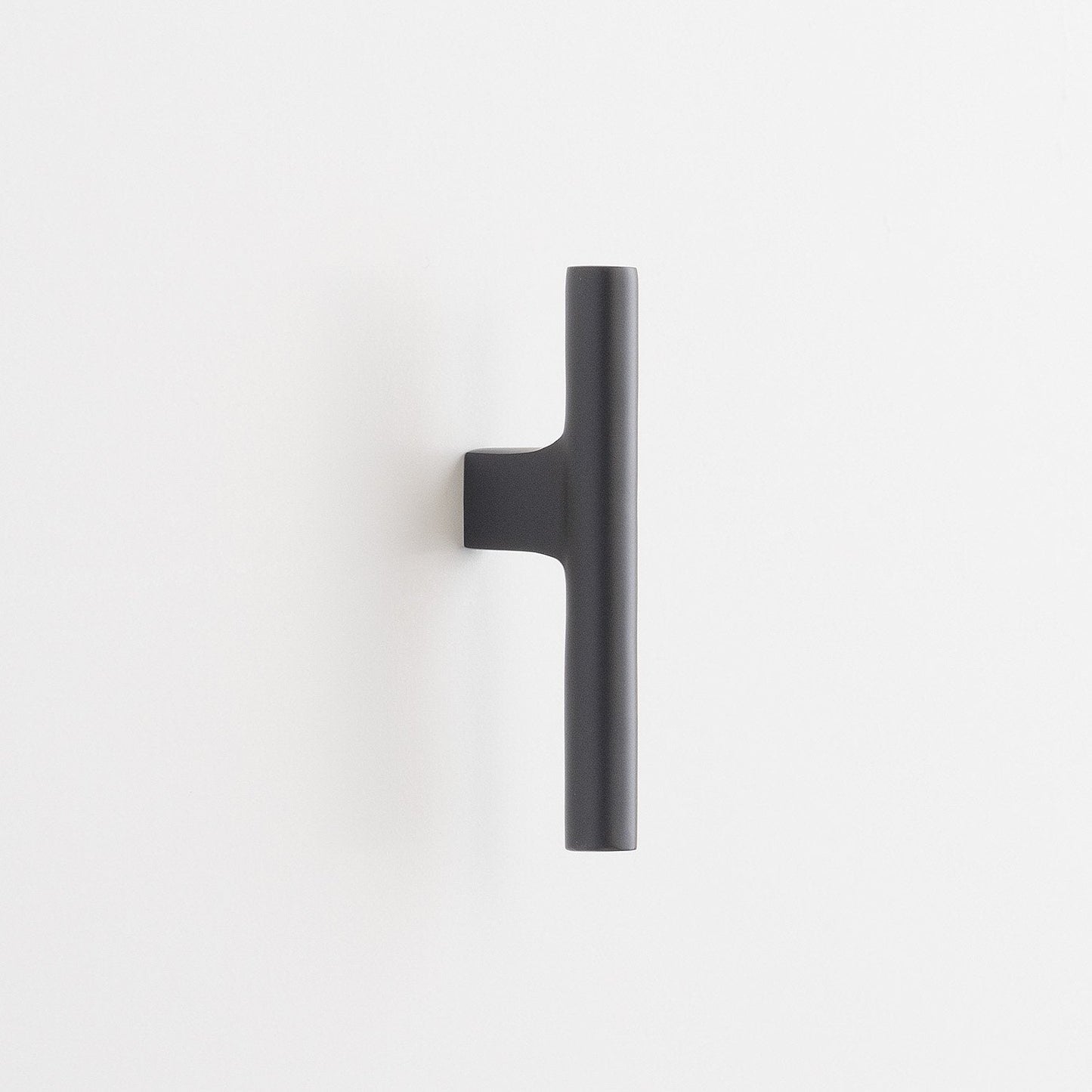 Vertical view of Galley Pull showing matte black cylindrical bar with offset mounting bracket on white background