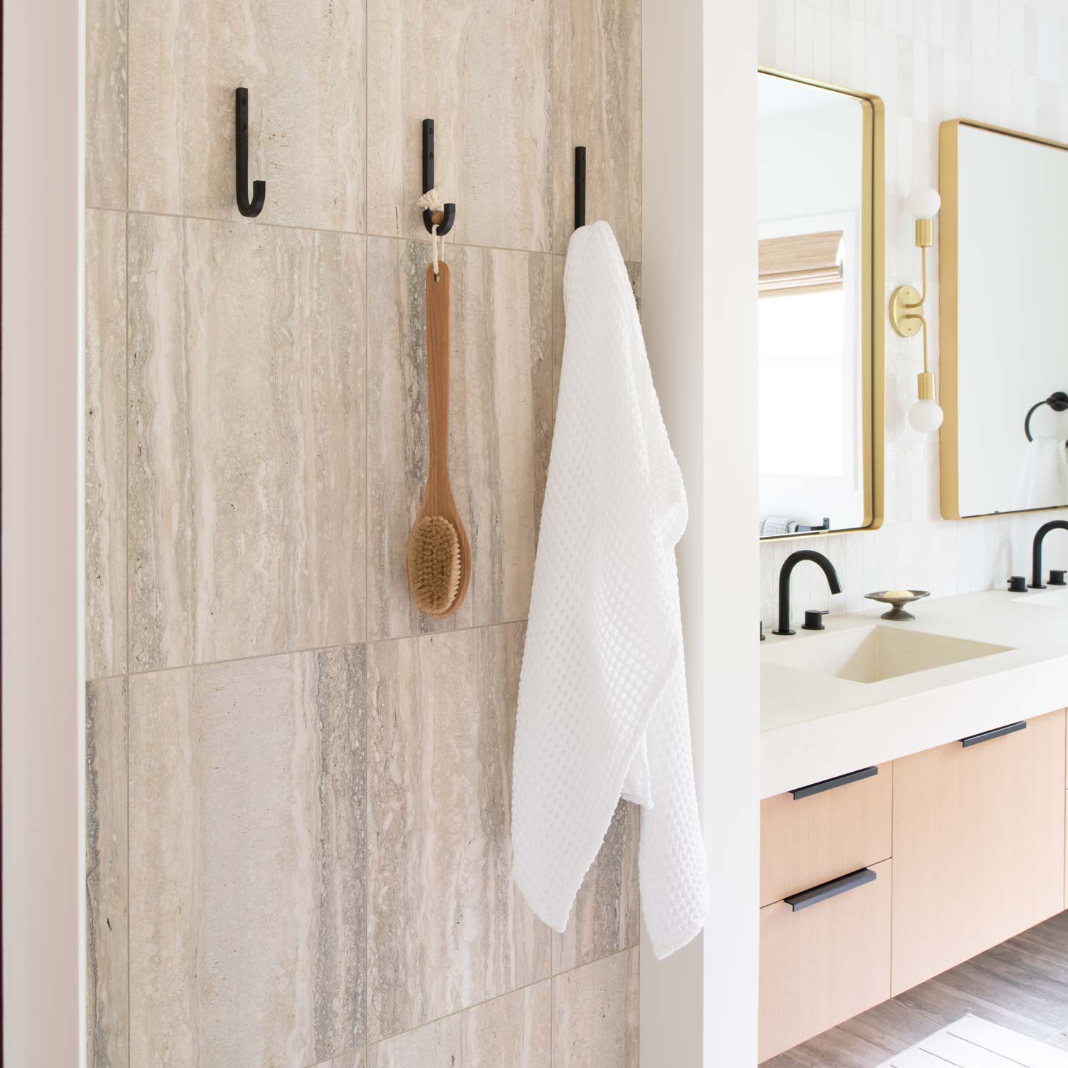 Close-up of J Hook in true black showcasing curved hook and slim profile on a tiled bathroom wall beside a vanity