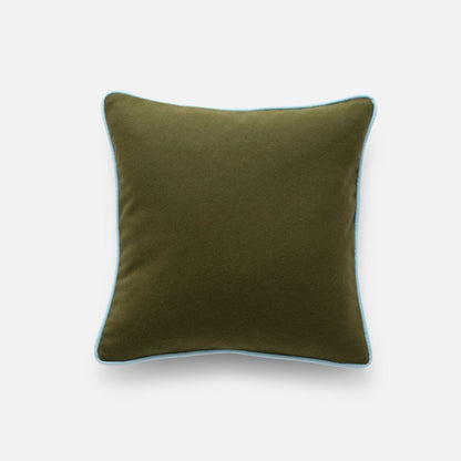 Top-down view of Classic Piped Pillow in olive with light blue piped edge, square throw pillow on light gray background