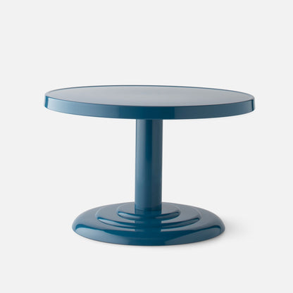 Close-up front view of Owen Cocktail Table showcasing round tabletop, stepped pedestal base, and Pool-Gloss finish on a light background