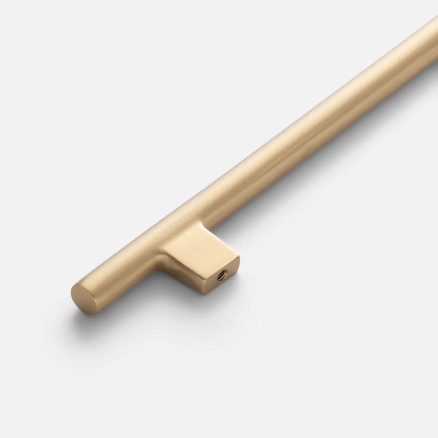 Angled close-up of Galley Pull showing brushed natural brass cylindrical bar and square mounting detail on white background