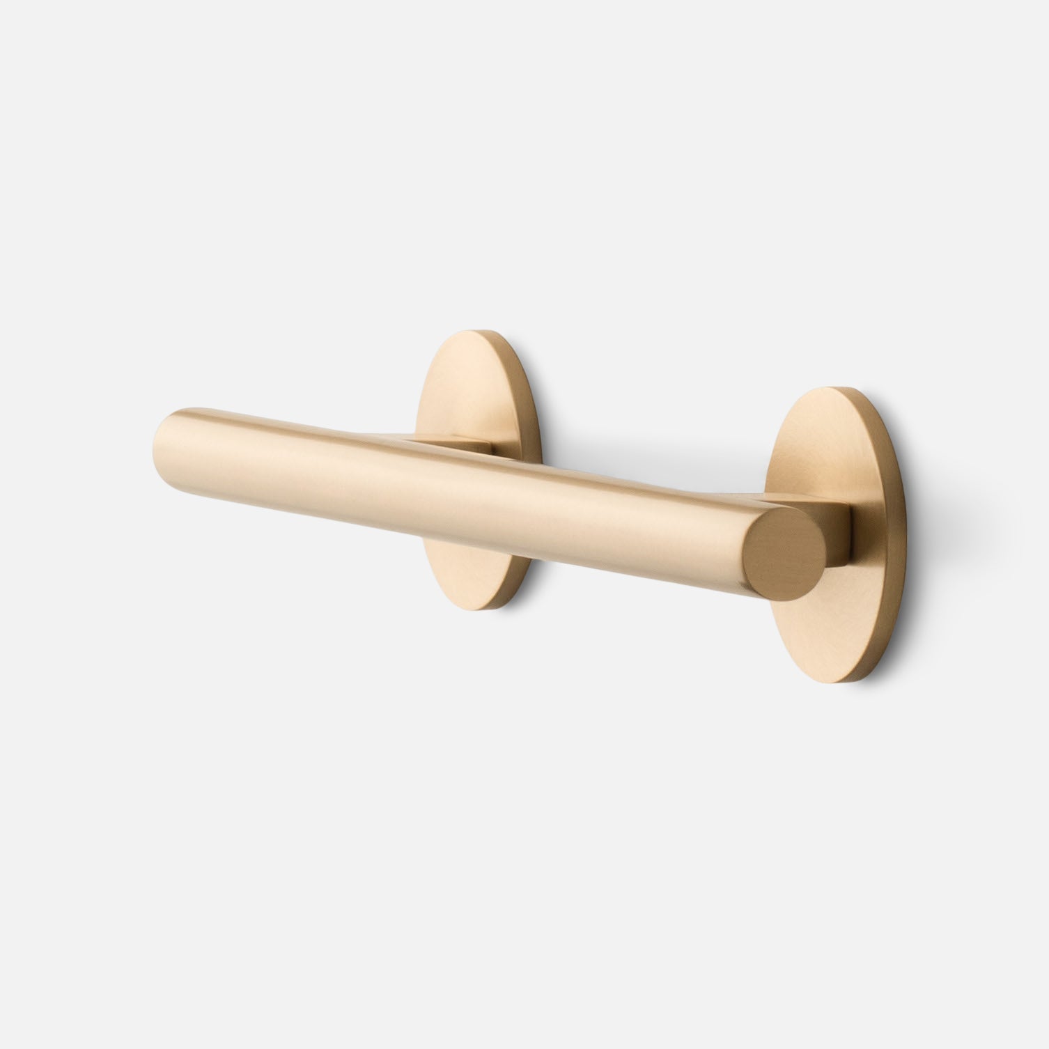 Angled close up of Galley Pull in natural brass showing tubular bar and round back plate on white background