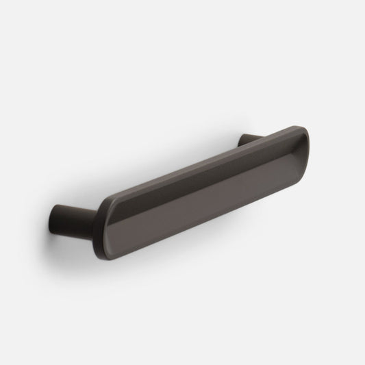 Angled front view of Rhone cabinet pull showing its rounded rectangular bar and tapered ends in matte dark bronze on a light gray background