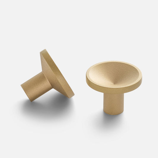 Angled and top views of Rhone knob showcasing concave dish top and brushed brass finish on white background