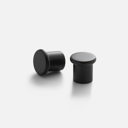 Three-quarter view of Remy Knob showing soft curved top and short cylindrical stem in matte black finish on white background