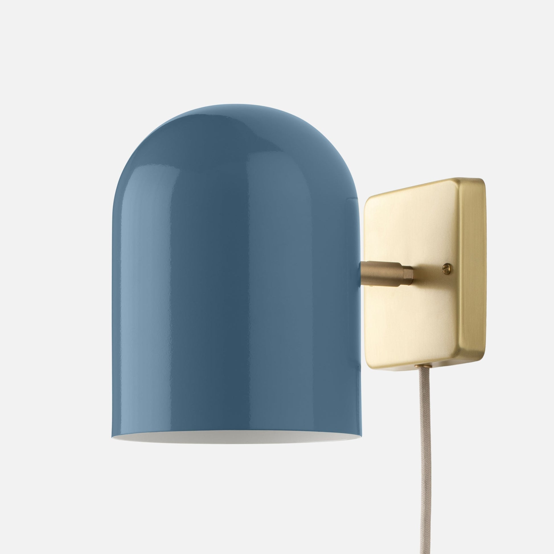 Close-up side view of Allegheny 6-inch Plug-In Sconce showing blue dome shade, brass wall plate, and fabric-covered plug-in cord on white background