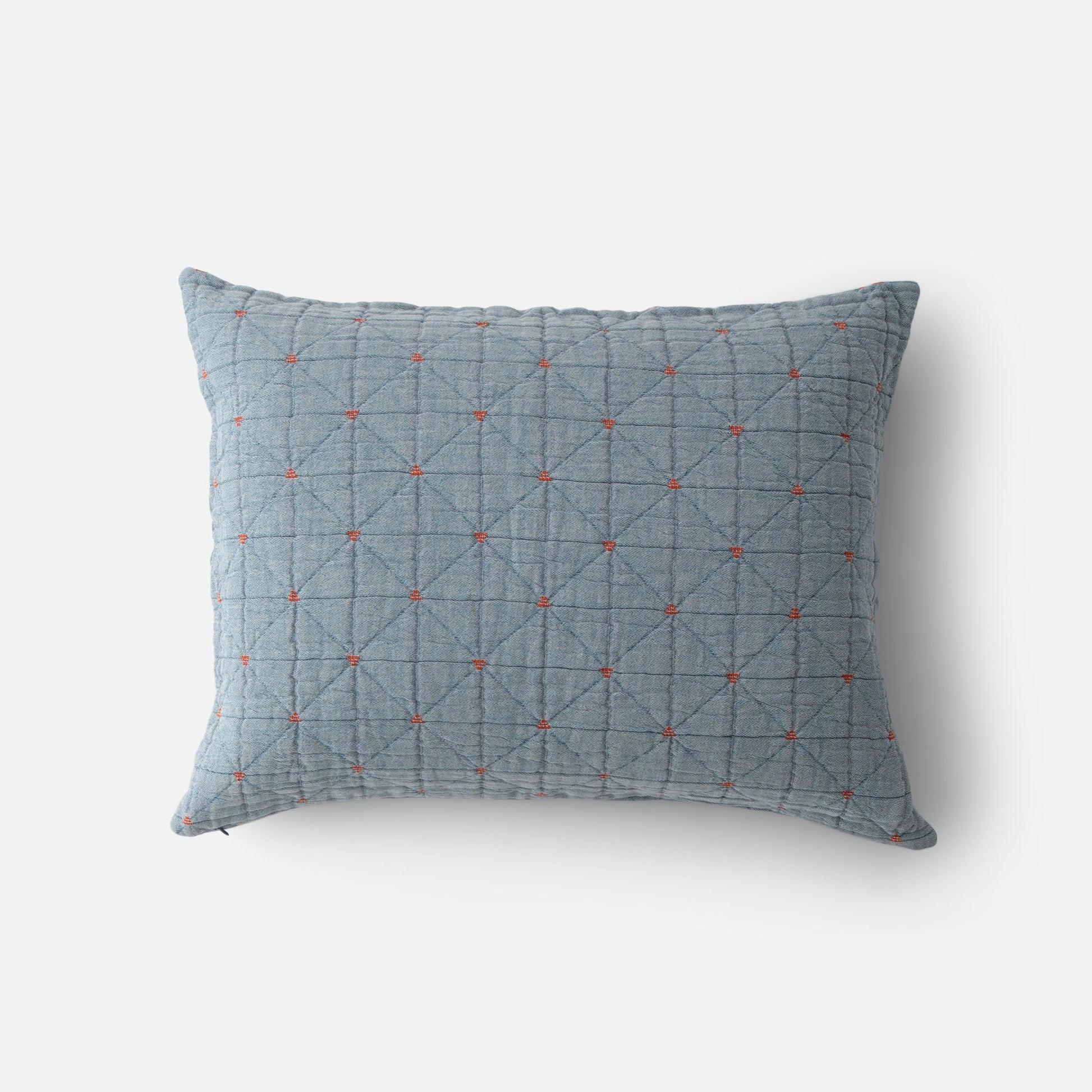Top view of Peak Stitch sham showing blue quilted fabric with diamond grid and small red embroidered crosses on white background