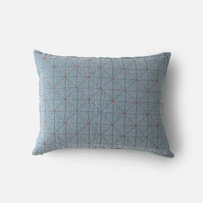Top view of Peak Stitch sham showing blue quilted fabric with diamond grid and small red embroidered crosses on white background